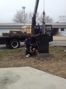 Workers from Wellwood Memorials prepare the centerpiece for transfer